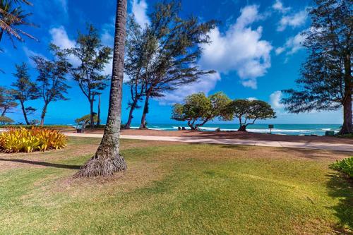 a park with trees and the ocean in the background at Islander on the Beach 164 in Kapaa