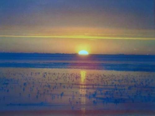 a sunset over the water with the sun in the horizon at Super Pet Friendly 2 Bedroom Caravan Heacham Beach in Heacham