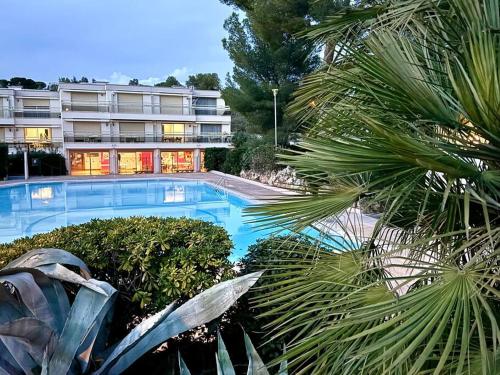 une grande piscine devant un immeuble dans l'établissement Rez-jardin rénové à Saint-Raphaël, Côte d'Azur, à Saint-Raphaël