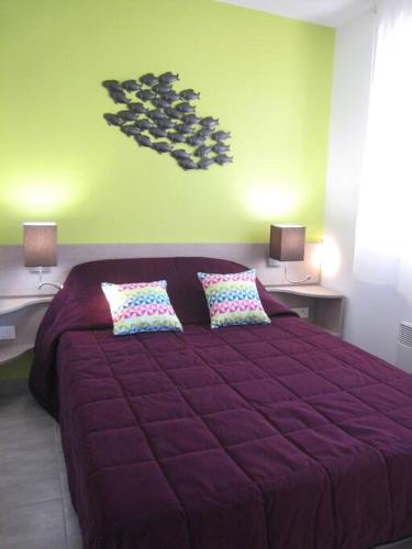 - un lit violet avec deux oreillers dans une chambre dans l'établissement Rez-jardin rénové à Saint-Raphaël, Côte d'Azur, à Saint-Raphaël