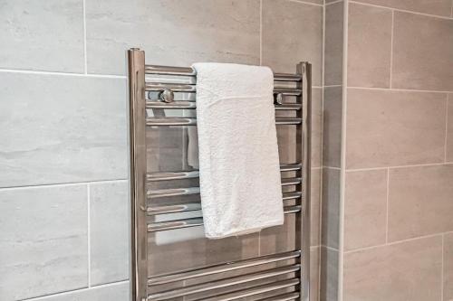 a towel rack in a shower with a towel at Luxury Short Stay Apartment in Hounslow