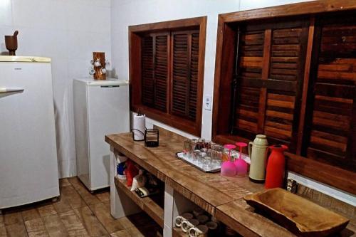 サン・フランシスコ・ド・スルにあるChácara Rota das Praias - Ubatuba - São Francisco do Sulの冷蔵庫とカウンター付きの木製カウンターのあるキッチン sidx sidx