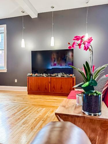 a living room with a tv and a table at The Historic Lyric Penthouse with Private Rooftop in Cincinnati