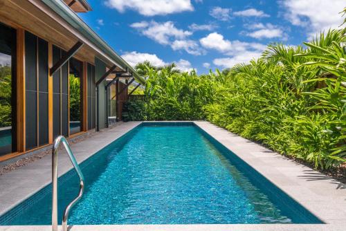 a swimming pool in front of a house at Yangaro in Airlie Beach