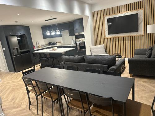 a kitchen and living room with a table and chairs at 6 bedroom house in Orpington in Farnborough