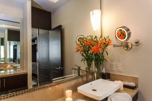a bathroom with a sink and a vase of flowers at Pinnacle Resorts at Zona Romantica in Puerto Vallarta
