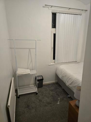 a small bedroom with a bed and a window at Poshval in Manchester