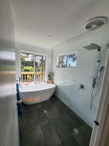 a large bathroom with a tub and a shower at Bushland View Retreat in Ocean Shores
