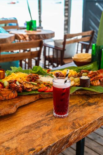 a table with a plate of food and a drink at B4 BOUTIQUE in Paje