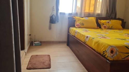 a bedroom with a bed with yellow sheets and a window at Odoux in Adékplovi