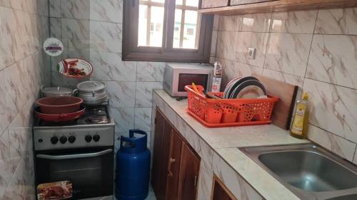 a kitchen with a sink and a microwave at Odoux in Adékplovi