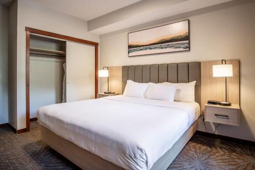 キャンモアにあるPremium King suite with views and poolの大型ベッド1台とランプ2つが備わるホテルルームです。