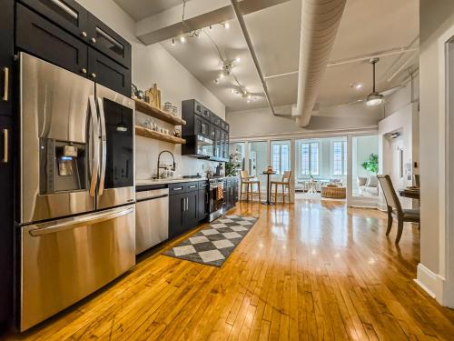 a large kitchen with wooden floors and stainless steel appliances at The Historic Lyric Presidential Suite in Cincinnati