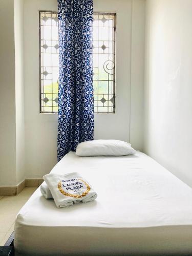 a bed in a room with two windows at Laurel plaza 46 in Montería