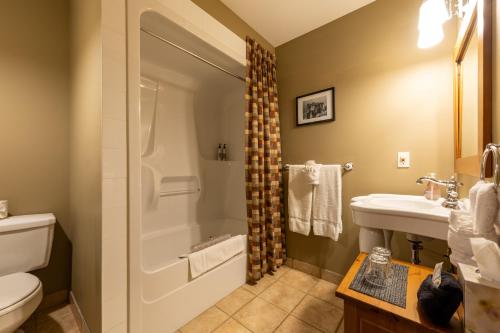 a bathroom with a shower and a sink and a toilet at Vagabond Lodge at Kicking Horse in Golden