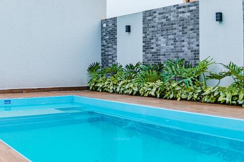 una piscina di fronte a un edificio con piante di Espaço Elegante e Completo no Coração da Cidade a Toledo