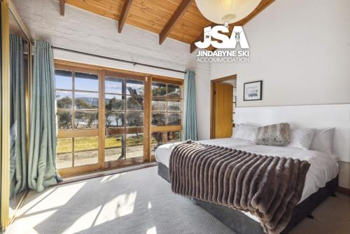 a bedroom with a bed and a large window at Beulah by the Lake in Kalkite