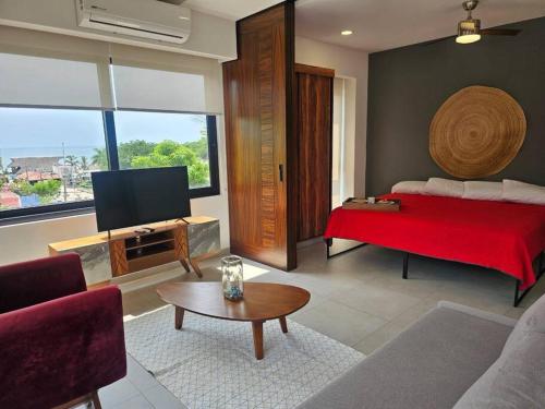 a living room with a red bed and a tv at Cómodo Apartamento zona Romántica con alberca 503 in Puerto Vallarta
