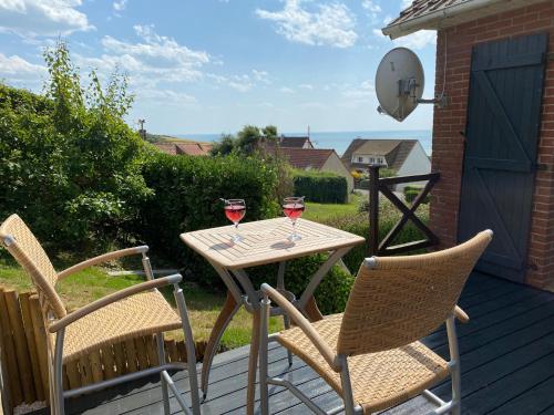 deux verres de vin assis sur une table sur une terrasse dans l'établissement Maison avec vue mer sur les hauteurs d'Equihen-Plage, à Équihen-Plage
