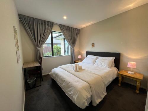 a bedroom with a large bed and a window at Wigram sunny quiet home in Christchurch