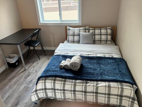 a bedroom with a bed with two towels on it at Room in neat comfy house in Kitchener