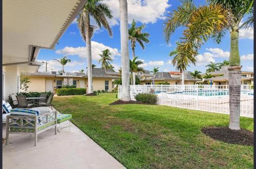 a backyard with palm trees and a fence at Dolphin Getaway in Marco Island