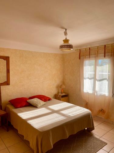 une chambre avec un lit et une fenêtre dans l'établissement Le Micocoulier, à La Crau