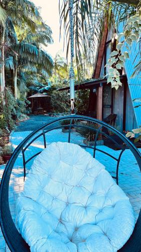 a metal bench with a white cushion on it at Chalé de madeira com vista para o rio in Pomerode