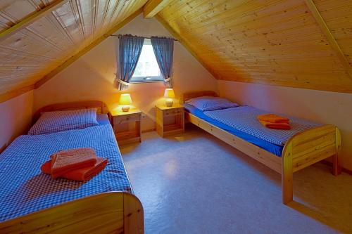a attic bedroom with two beds and a window at Ferienpark Markgrafenheide in Markgrafenheide