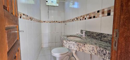 un baño con lavabo e inodoro en Casa Temporada Lua Nova, en Guriri