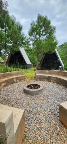 a fire pit in a gravel area with two buildings at Cabañas Siete Puntas in Mazamitla