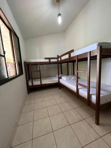 two bunk beds in a room with a tile floor at Refugio a Beira do lago Piscina Churrasqueira Vista privelegiada para o Por dos sol Canto dos Passaros in Capitólio