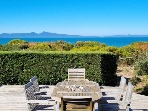 una mesa de madera y sillas con vistas al océano en Southerlys Beach House, en Dolphin Sands