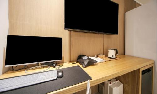 a desk with a computer monitor and a keyboard and mouse at From H Lazy Heaven in Changwon