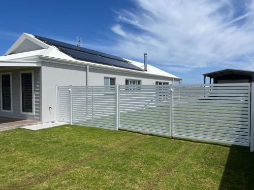 a white house with a fence in front of it at Foxhill Shores - WIFI outside pets in Robe