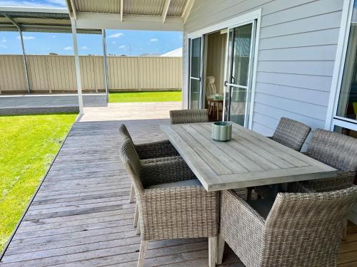 a patio with a wooden table and chairs at Foxhill Shores - WIFI outside pets in Robe