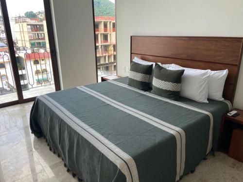 a bedroom with a large bed with a large window at Francisca Luxury Suites - Adults Only in Puerto Vallarta