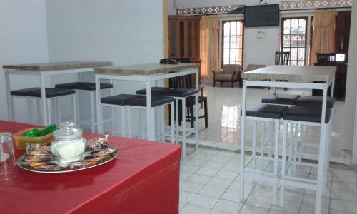 a room with bar stools and a plate of food on a table at Pondok Heras Suite in Jakarta