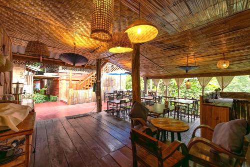 a restaurant with wooden floors and tables and chairs at Monruamsuk Homestay Cafe and Bistro in Chiang Mai