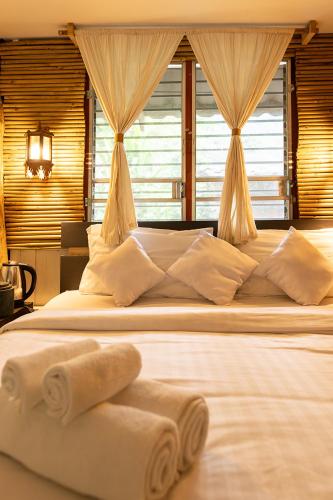 a bedroom with a large bed with towels on it at Monruamsuk Homestay Cafe and Bistro in Chiang Mai