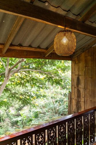 a pendant light hanging from the ceiling of a porch at Monruamsuk Homestay Cafe and Bistro in Chiang Mai