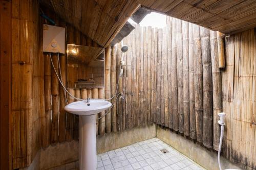 a bathroom with a sink in a wooden wall at Monruamsuk Homestay Cafe and Bistro in Chiang Mai