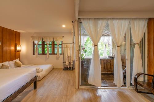 a bedroom with a bed and a large window at Monruamsuk Homestay Cafe and Bistro in Chiang Mai