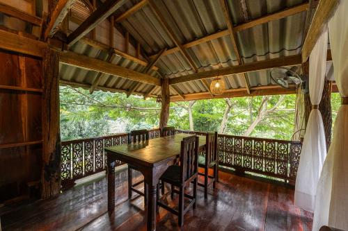 a dining room with a table and chairs on a balcony at Monruamsuk Homestay Cafe and Bistro in Chiang Mai