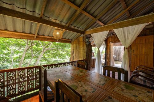 a dining room with a wooden table and chairs at Monruamsuk Homestay Cafe and Bistro in Chiang Mai