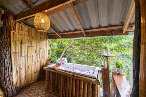 a bathroom with a bath tub in a house at Monruamsuk Homestay Cafe and Bistro in Chiang Mai