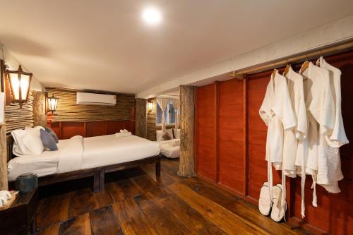 a bedroom with a bed and a bunch of clothes at Monruamsuk Homestay Cafe and Bistro in Chiang Mai