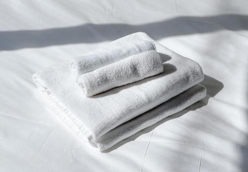 una pila de toallas blancas sentadas en una cama en trias527 1-1, en Tokio