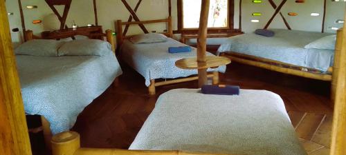 a room with two twin beds and a table at Hotel La Casa de Francois in San Agustín