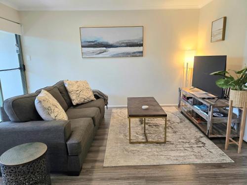 a living room with a couch and a table at Noosa River Retreat Holiday Apartments in Noosaville